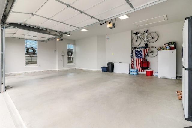 garage featuring white fridge and a garage door opener