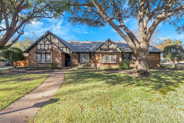 tudor-style house featuring a front yard