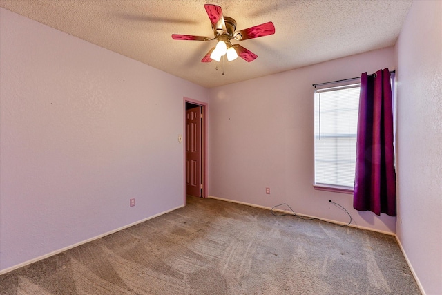 carpeted spare room with ceiling fan and a textured ceiling