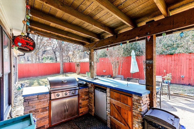 view of patio with a bar, an outdoor kitchen, and a grill