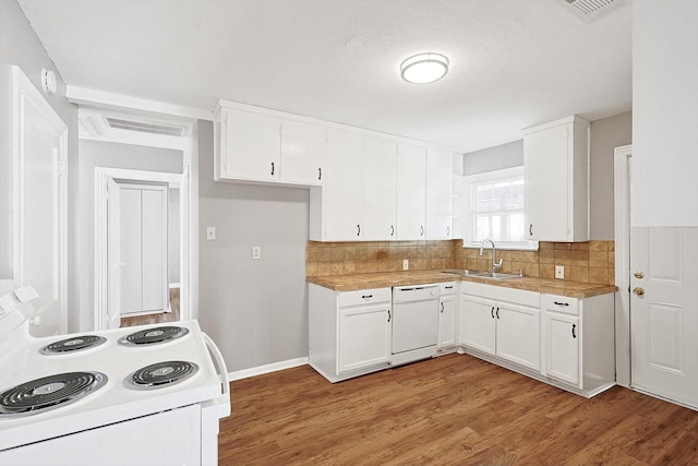 kitchen with white appliances, white cabinets, sink, light hardwood / wood-style flooring, and tasteful backsplash