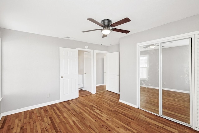 unfurnished bedroom featuring a closet, hardwood / wood-style flooring, and ceiling fan