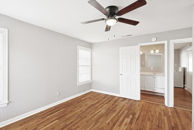 unfurnished bedroom with hardwood / wood-style flooring, ensuite bath, ceiling fan, and sink