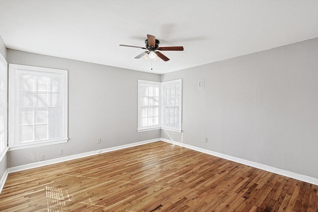 spare room featuring ceiling fan, light hardwood / wood-style floors, and a wealth of natural light