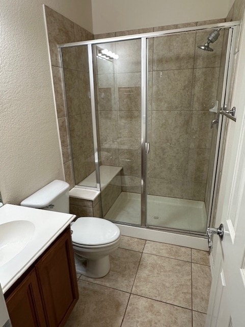 bathroom featuring vanity, walk in shower, tile patterned floors, and toilet