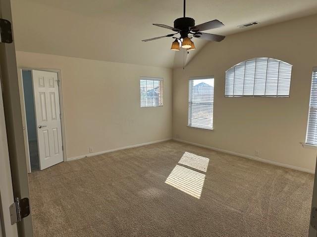 carpeted empty room featuring ceiling fan and lofted ceiling