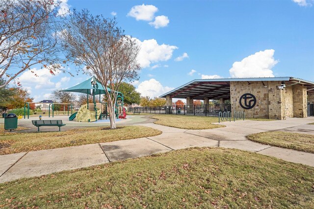 view of property's community featuring a playground and a lawn