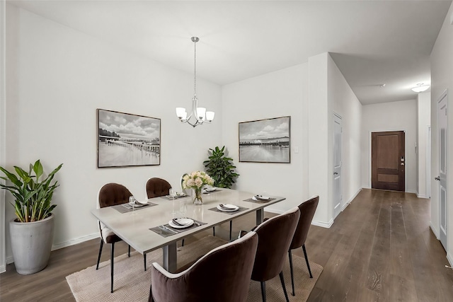 dining area featuring dark hardwood / wood-style flooring and an inviting chandelier