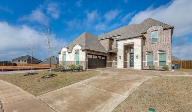 french country style house featuring cooling unit, a garage, and a front lawn