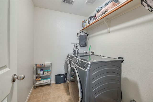 laundry room featuring light tile patterned floors and washing machine and dryer