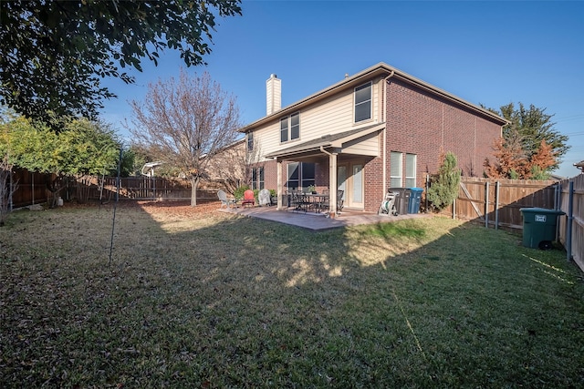 back of property with a yard and a patio