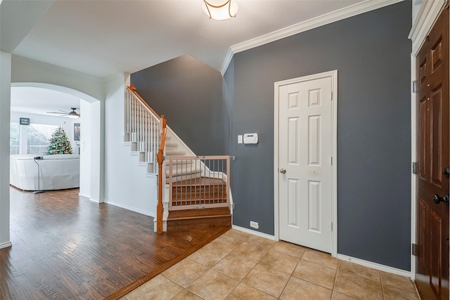 15404 Adlong Dr, Fort Worth, TX 76262 - foyer entrance with crown molding, a ceiling fan, stairs, arched walkways, and light wood-style flooring