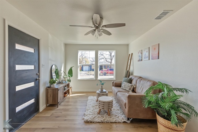 living room featuring light hardwood / wood-style flooring and ceiling fan