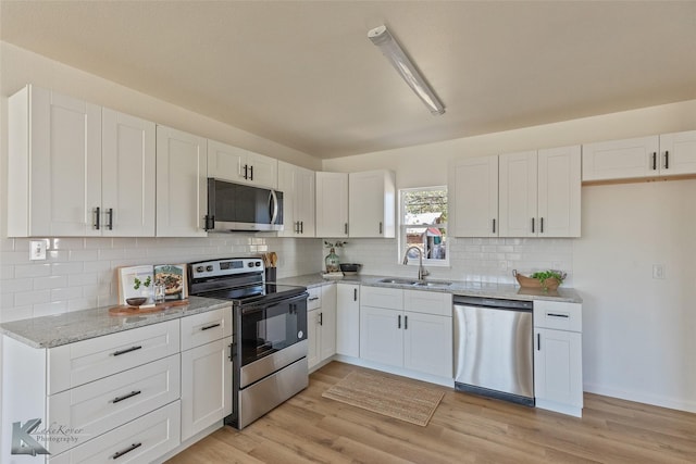 kitchen with appliances with stainless steel finishes, white cabinetry, and sink