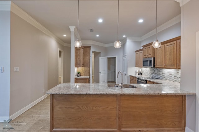 kitchen with sink, decorative light fixtures, light stone counters, kitchen peninsula, and stainless steel appliances