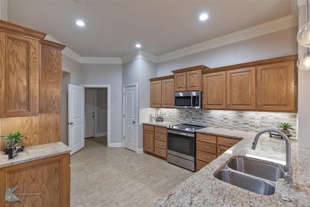 kitchen with light stone countertops, sink, stainless steel appliances, light hardwood / wood-style floors, and ornamental molding