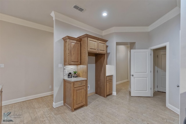 kitchen featuring light wood-type flooring, tasteful backsplash, light stone counters, and crown molding