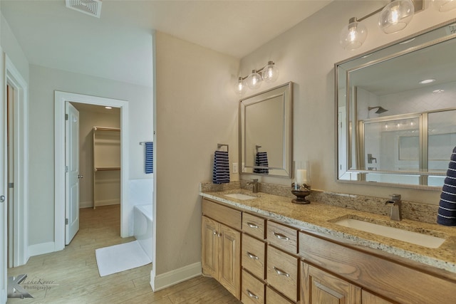 bathroom featuring plus walk in shower, vanity, and hardwood / wood-style flooring