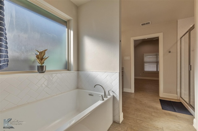 bathroom with hardwood / wood-style flooring and separate shower and tub