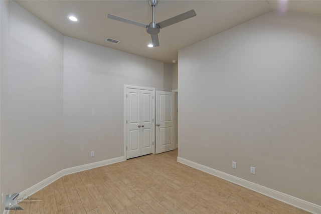 spare room with light hardwood / wood-style floors and lofted ceiling