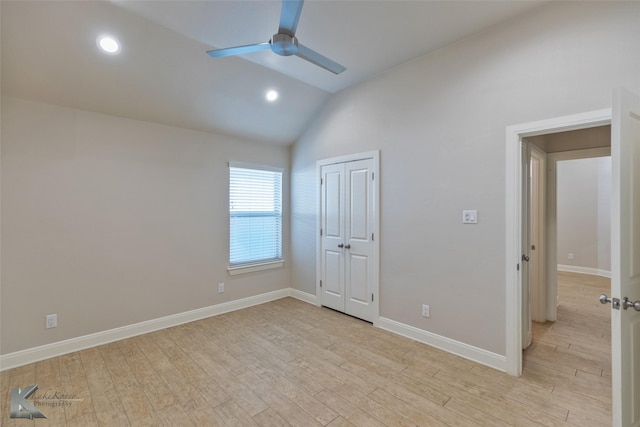 unfurnished bedroom featuring ceiling fan, a closet, light hardwood / wood-style flooring, and vaulted ceiling