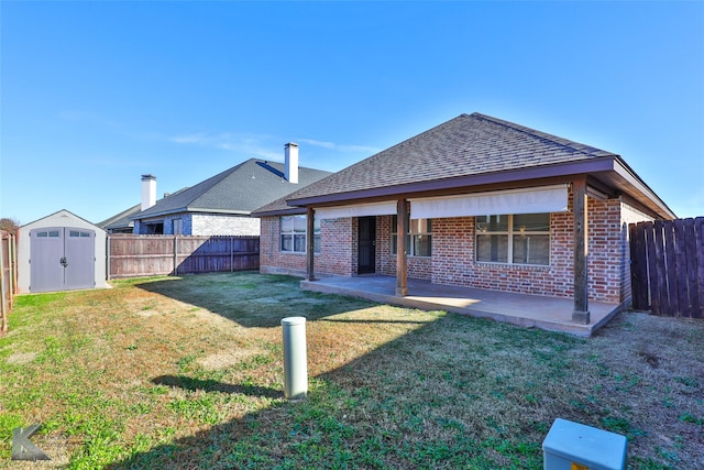 rear view of house featuring a lawn, a patio area, and a storage shed