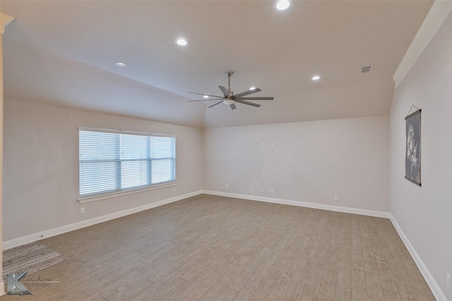 spare room with light hardwood / wood-style floors, vaulted ceiling, and ceiling fan