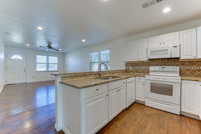 kitchen with kitchen peninsula, sink, white cabinets, and white appliances