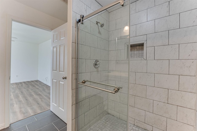 bathroom featuring hardwood / wood-style flooring and a shower with shower door