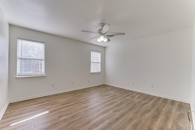 unfurnished room with wood-type flooring, a textured ceiling, a wealth of natural light, and ceiling fan