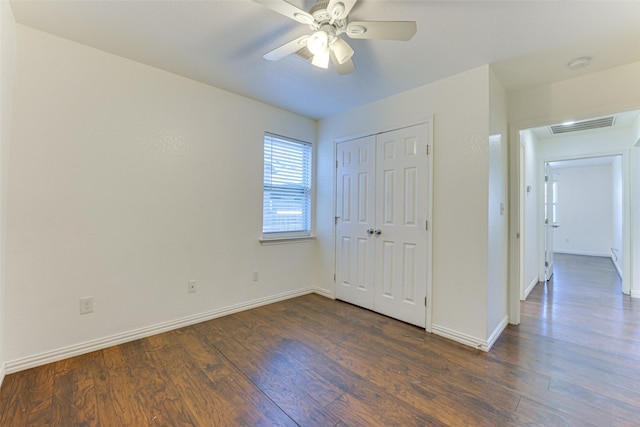 unfurnished bedroom with ceiling fan, a closet, and dark hardwood / wood-style floors