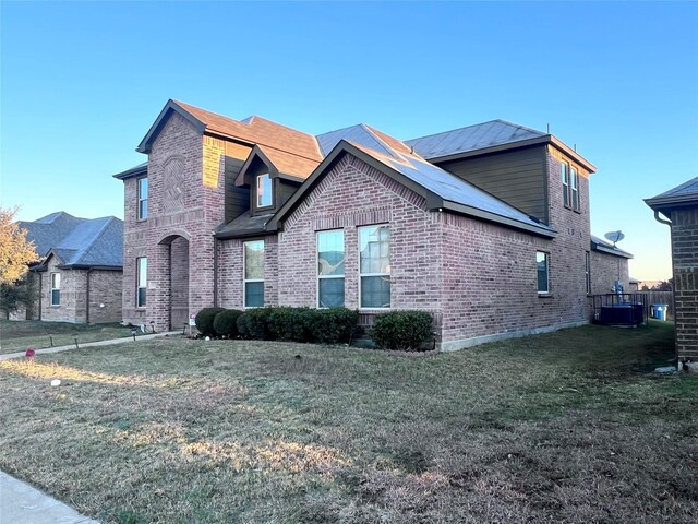 view of front facade featuring cooling unit and a front yard