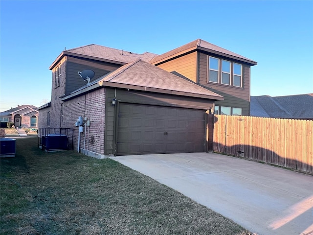 view of side of property with a garage, central AC unit, and a lawn