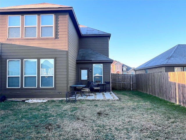 rear view of house featuring a patio and a lawn