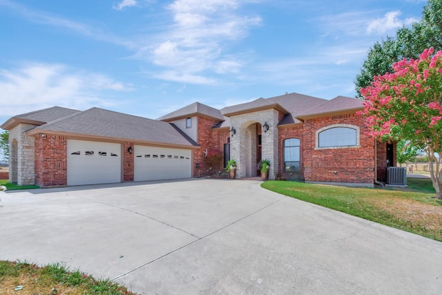 view of front of house with a front lawn, cooling unit, and a garage