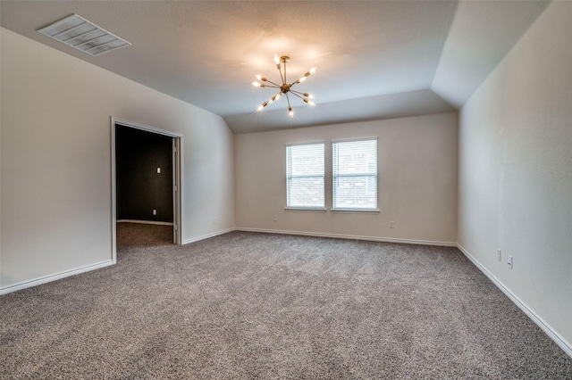 carpeted empty room with lofted ceiling and an inviting chandelier