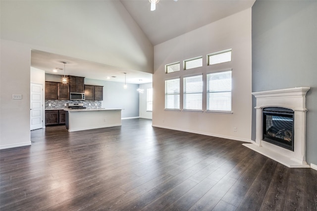 unfurnished living room with dark hardwood / wood-style floors and high vaulted ceiling