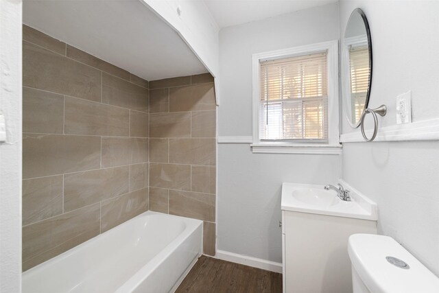 full bathroom with hardwood / wood-style floors, vanity, toilet, and tiled shower / bath