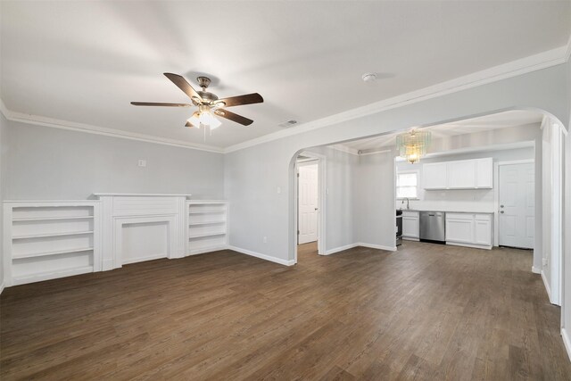 unfurnished living room with ceiling fan with notable chandelier, crown molding, and dark wood-type flooring