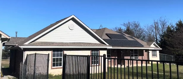 exterior space featuring a lawn and solar panels