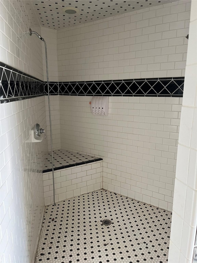 bathroom featuring tile patterned flooring and tiled shower