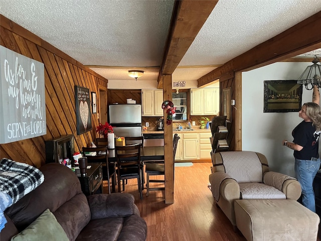 living room with wood walls, light hardwood / wood-style floors, and a textured ceiling