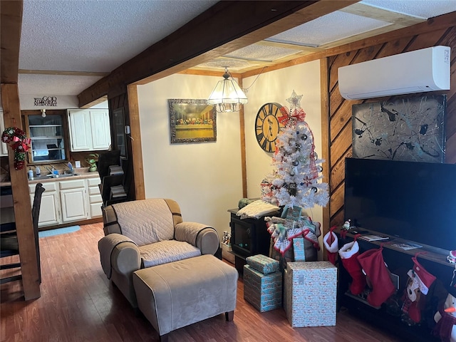 living room with a wall mounted air conditioner, hardwood / wood-style floors, wood walls, a textured ceiling, and a notable chandelier