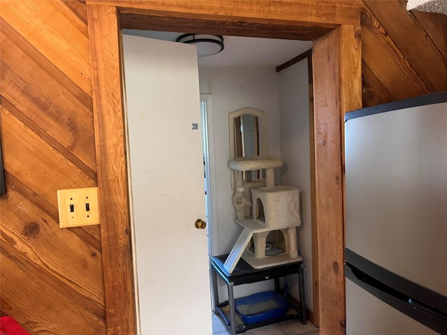 room details featuring white refrigerator and wooden walls