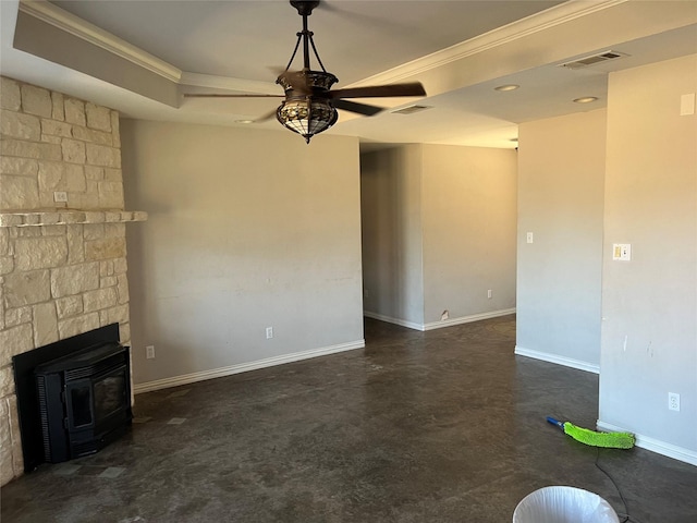 unfurnished living room featuring ceiling fan, a raised ceiling, a wood stove, and ornamental molding