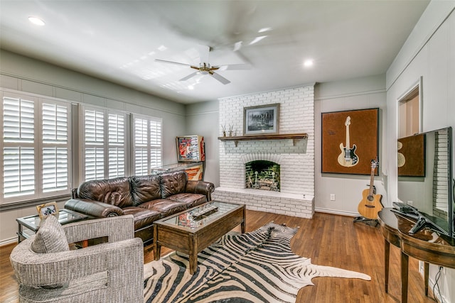 living room with ceiling fan, a fireplace, and wood-type flooring