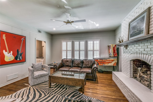 living room with ceiling fan, a fireplace, and dark wood-type flooring