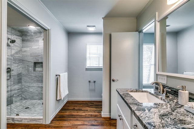 bathroom featuring wood-type flooring, vanity, an enclosed shower, and ornamental molding