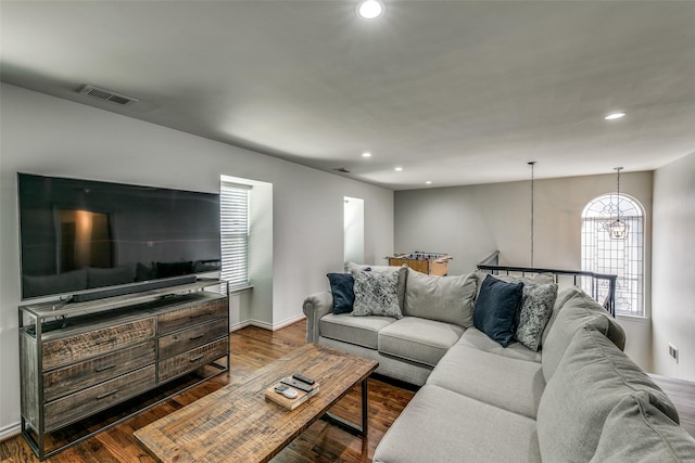 living room with dark wood-type flooring and an inviting chandelier