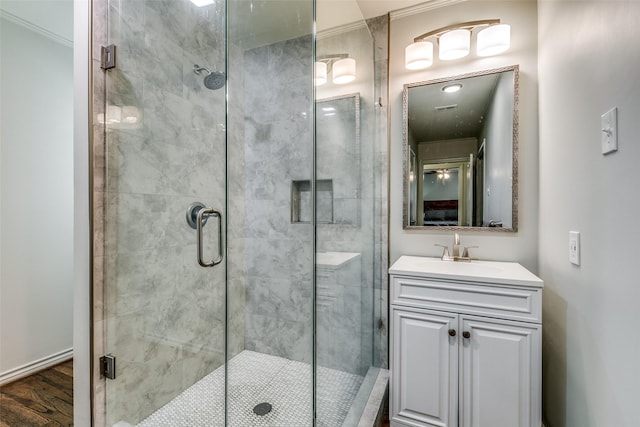 bathroom with vanity, hardwood / wood-style flooring, an enclosed shower, and ornamental molding